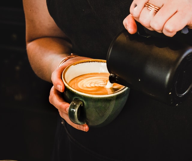 Summer job - barista hands pouring foam