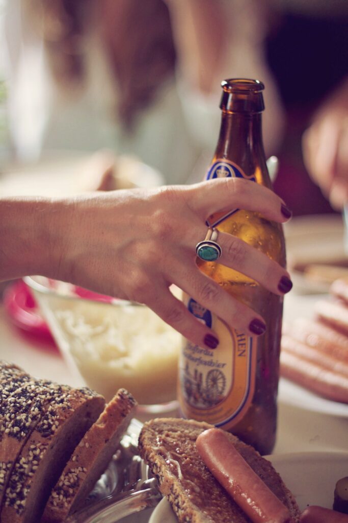 Try different cuisine on your trip to Germany - hand holding a beer bottle