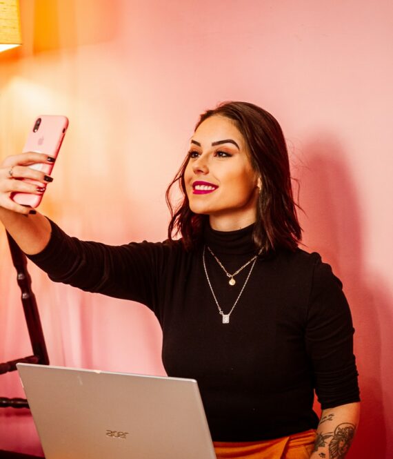 influencer marketing requires proper disclosure - woman takes a selfie against a pink wall